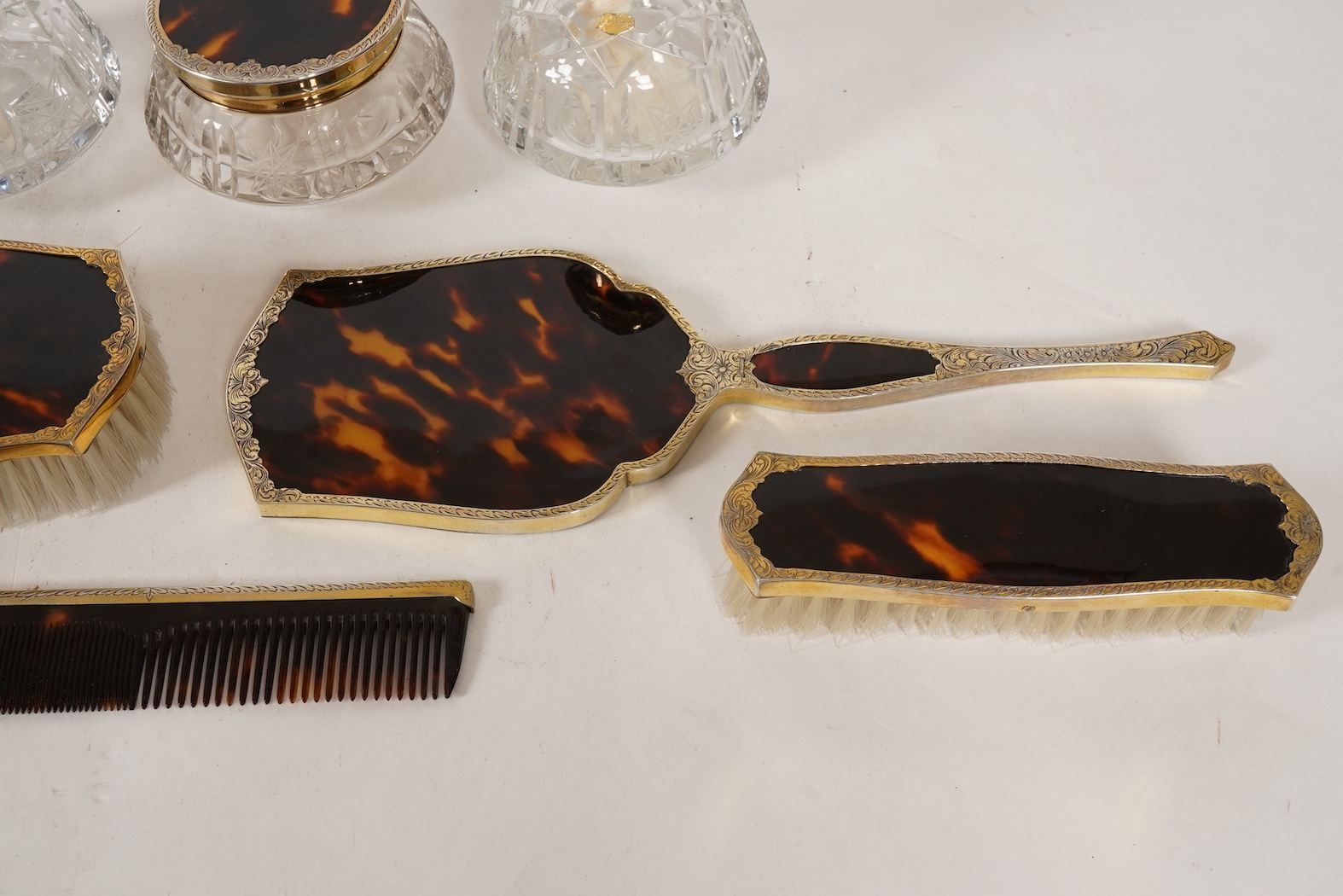 A mid 20th century continental eight piece gilt white metal and tortoiseshell mounted dressing table set